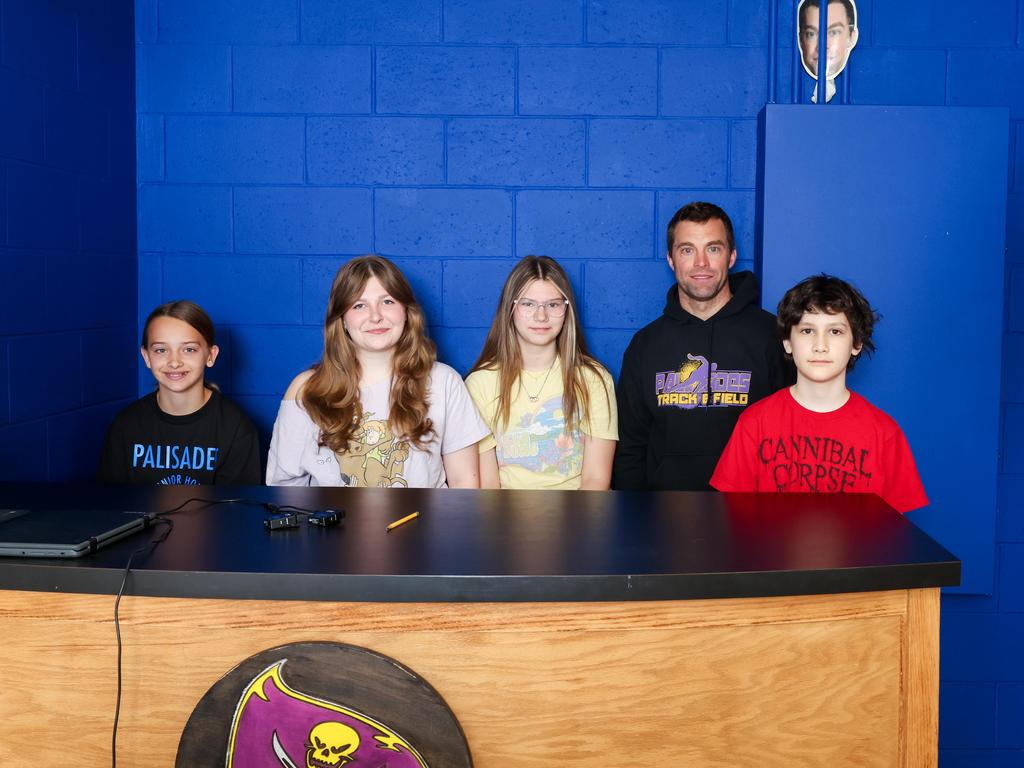 Video Production students sitting at a desk with their teacher.