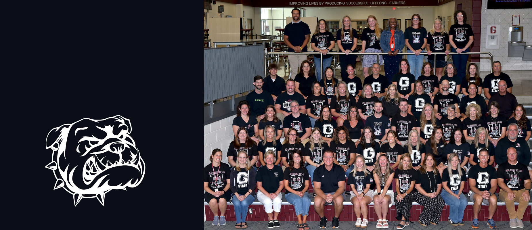 the grandville middle school staff all sit upon the stairs in the middle school in their black t-shirts