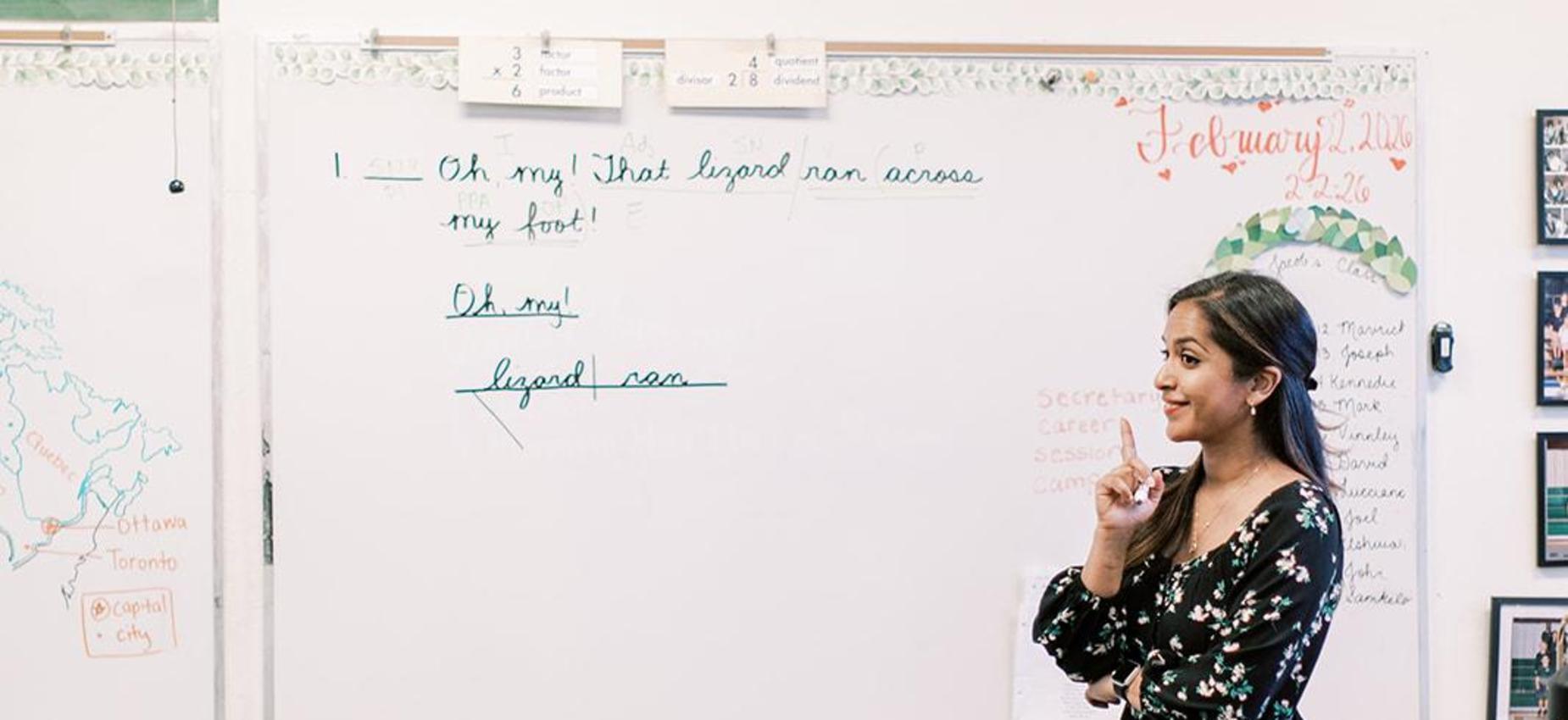 Teacher points to notes on the whiteboard during a lesson