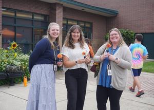 Three guests await the ribbon cutting.