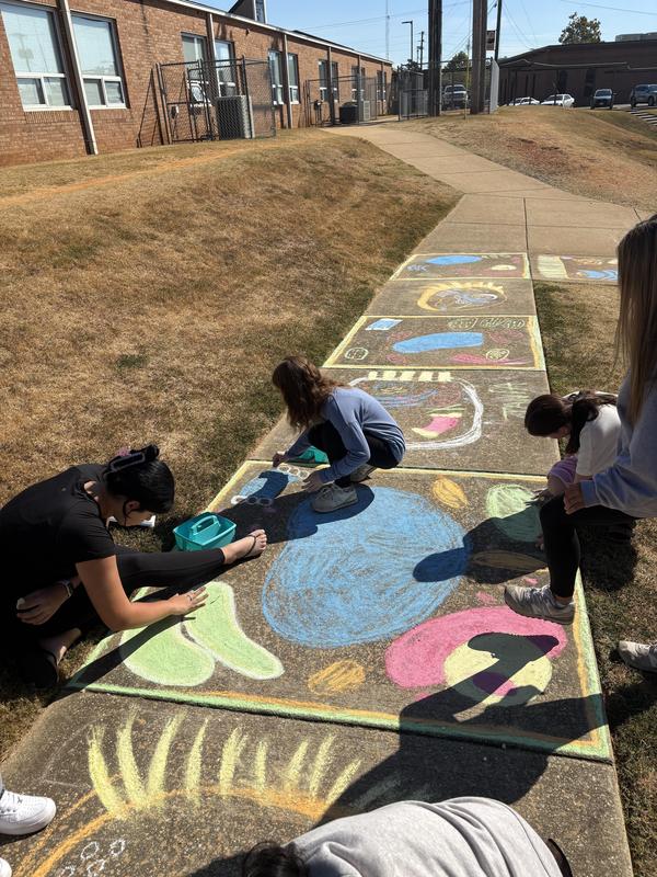 Group of students working on sidewalk art of the cell