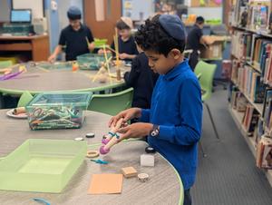 A boy working on his "invention" in library.