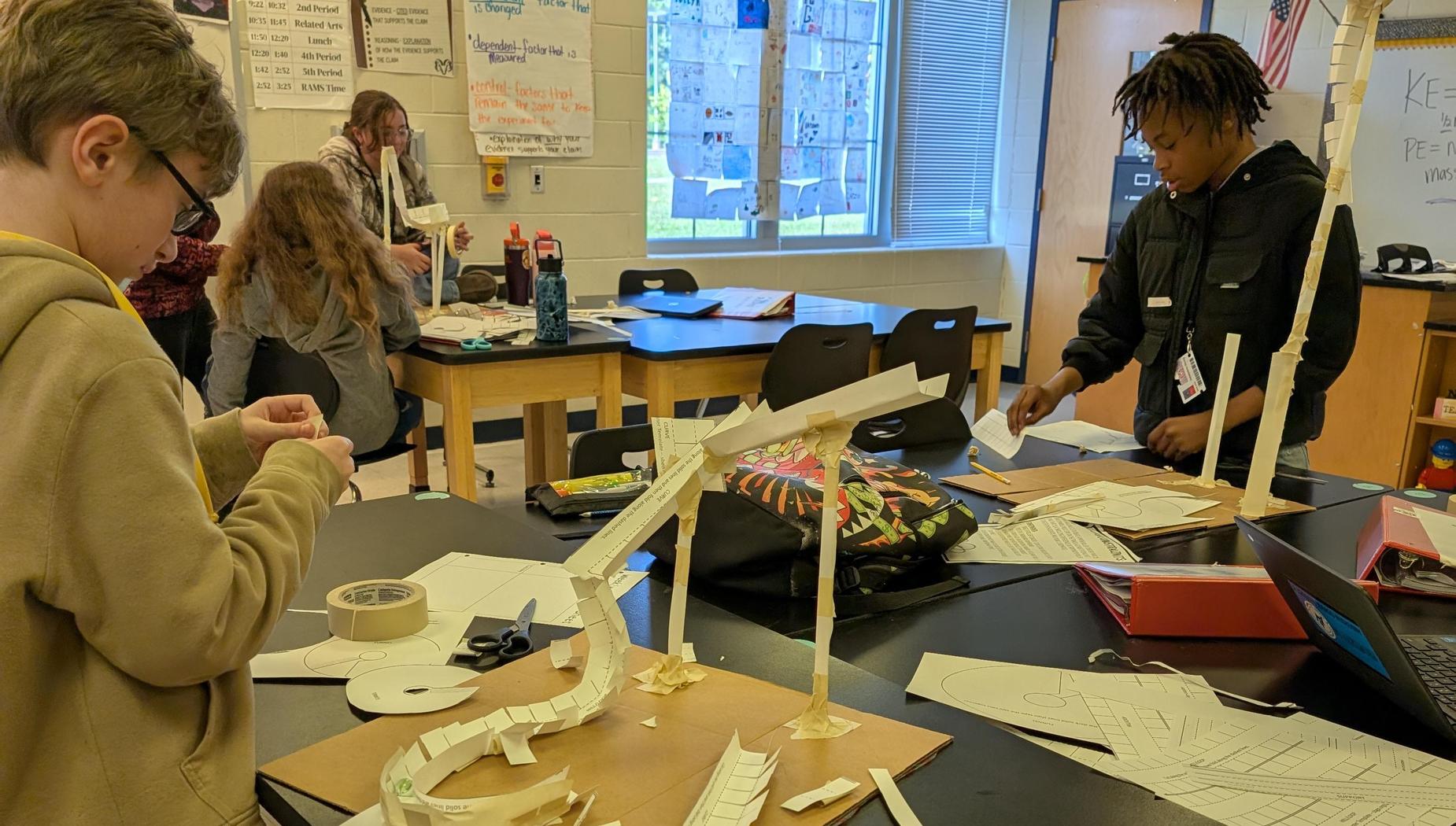 7th graders building roller coasters out of paper