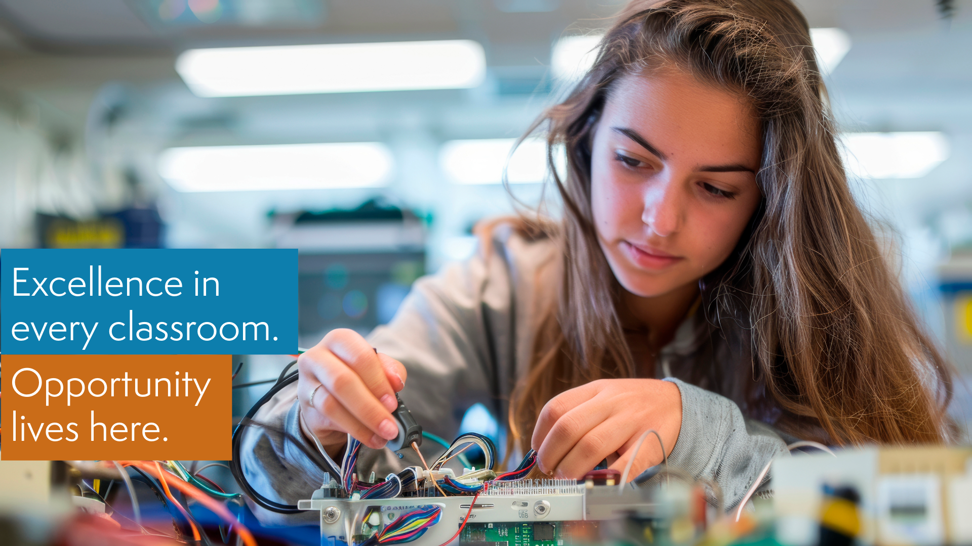 A teenage girl with long brown hair working on electronics in a classroom environment with a text overlay that reads, Excellence in every classroom. Opportunity lives here.