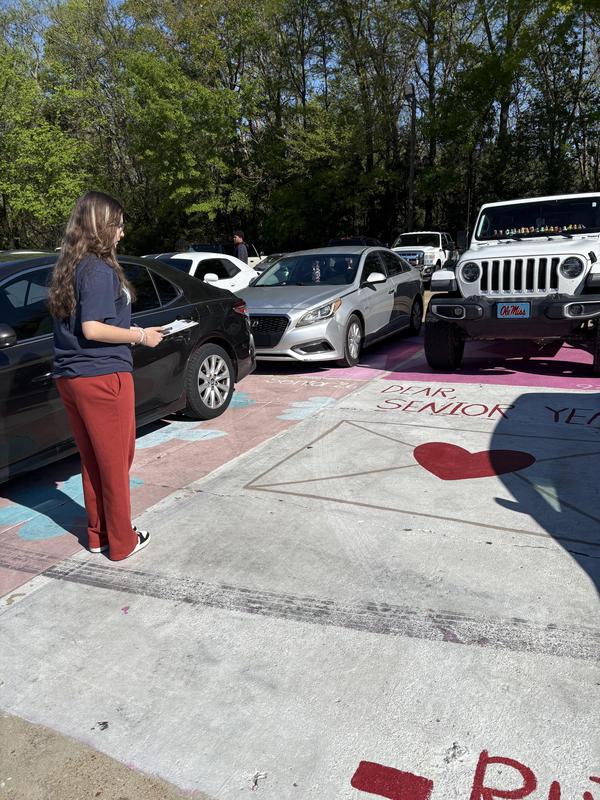 Students looking for polygons in the senior parking lot, at a painted parking space