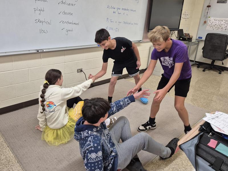 Students act out scenes using the meaning of a word