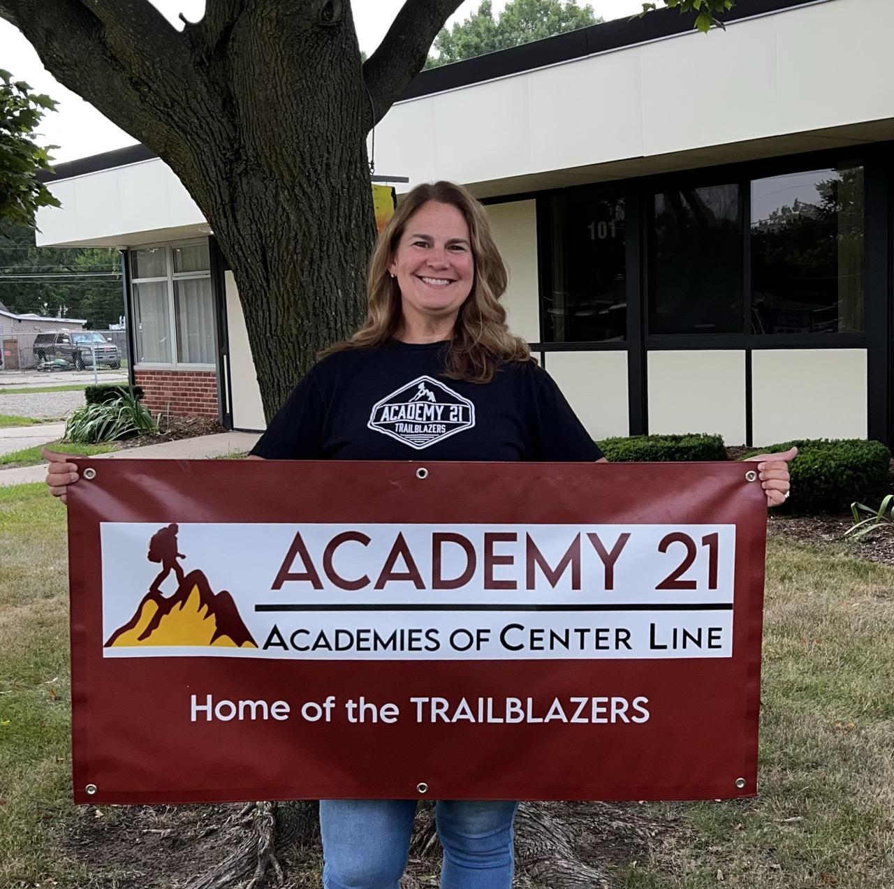 Jennifer Wickersham holding Academy 21 Banner