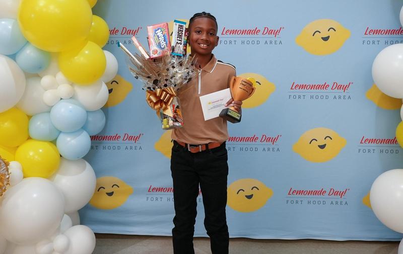 Boy holding awards and smiling