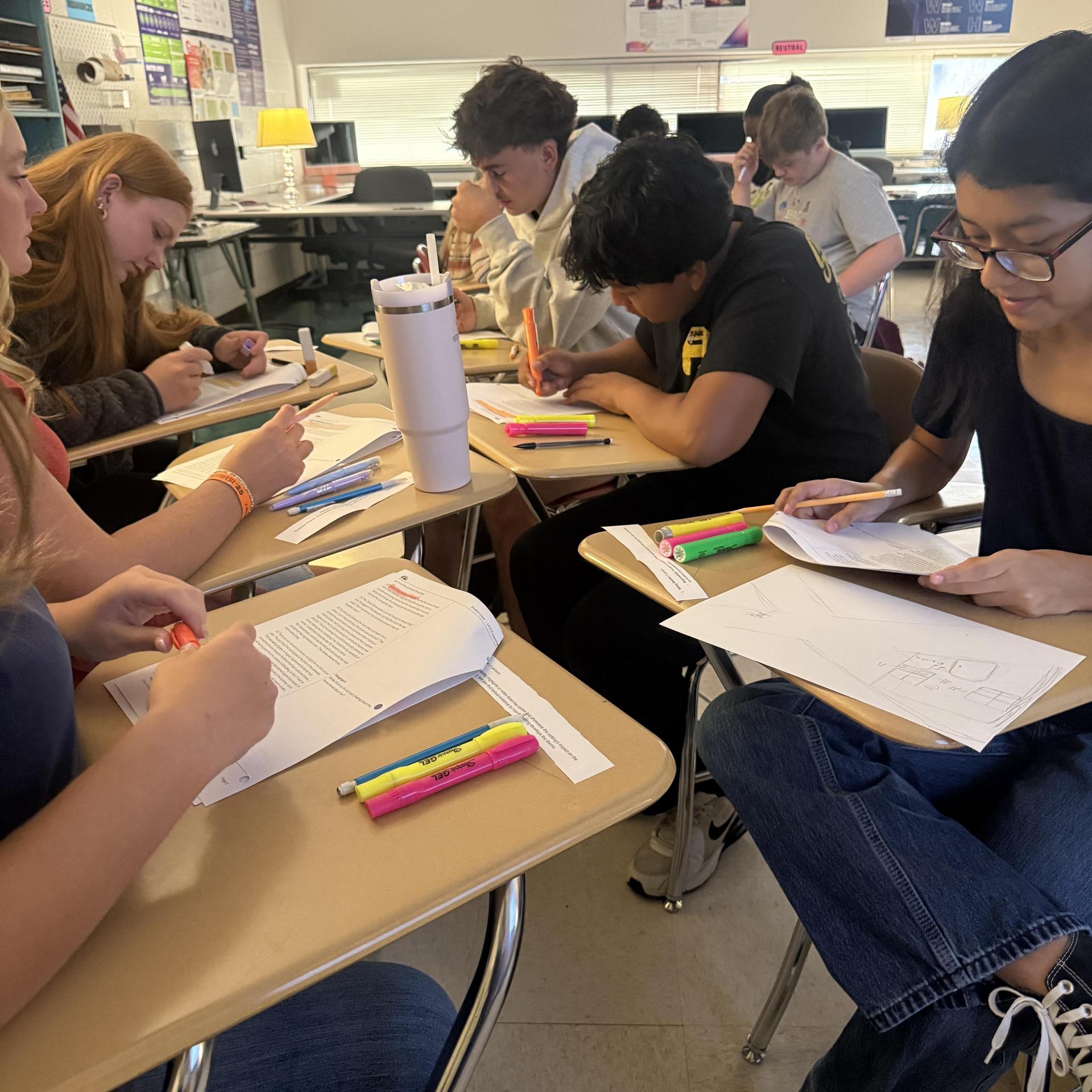 A classroom filled with students collaborating on assignments at their desks.