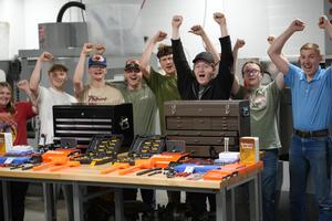 students cheering behind a set of tools on a table