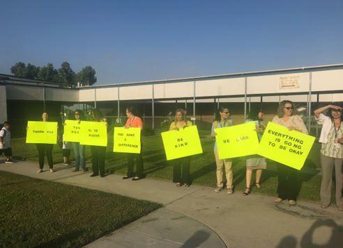 Teachers holding positive signs