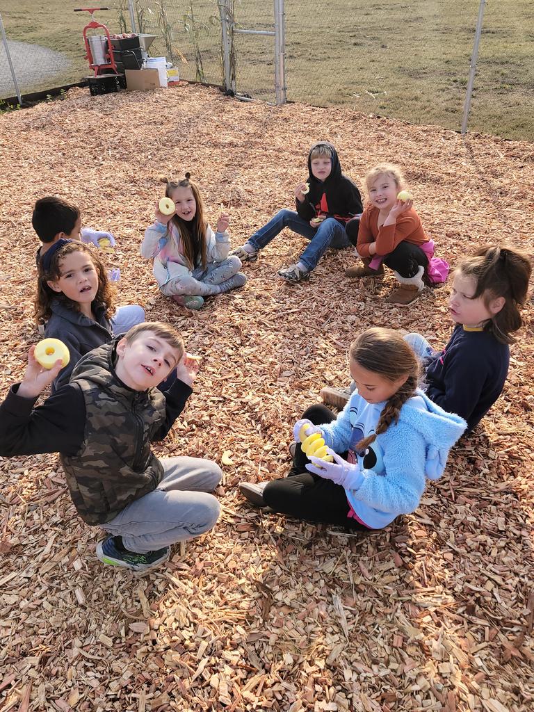 students in circle eating apples