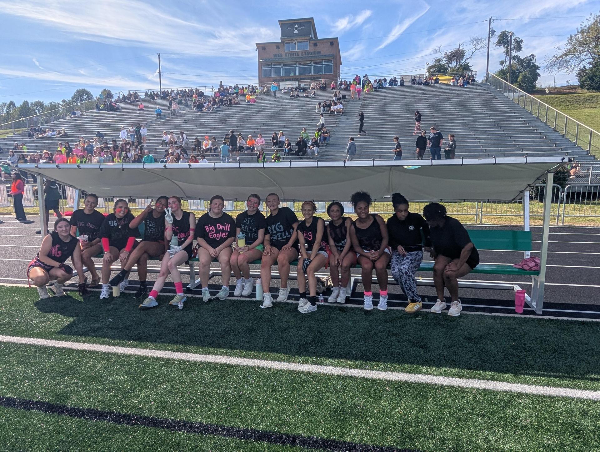 Cheerful group of athletes relaxing under a tent at a sports event.