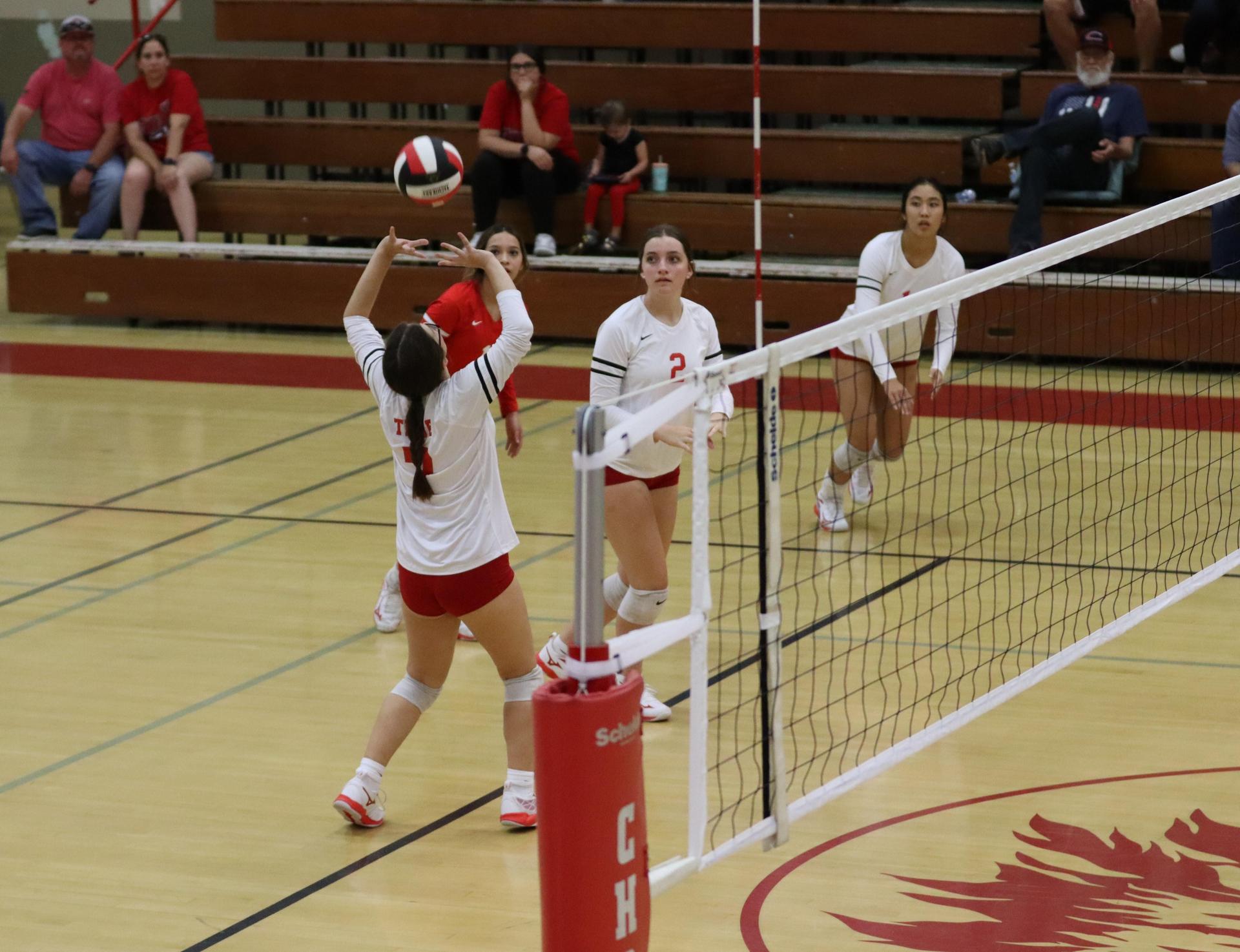 varsity volleyball players in action against liberty