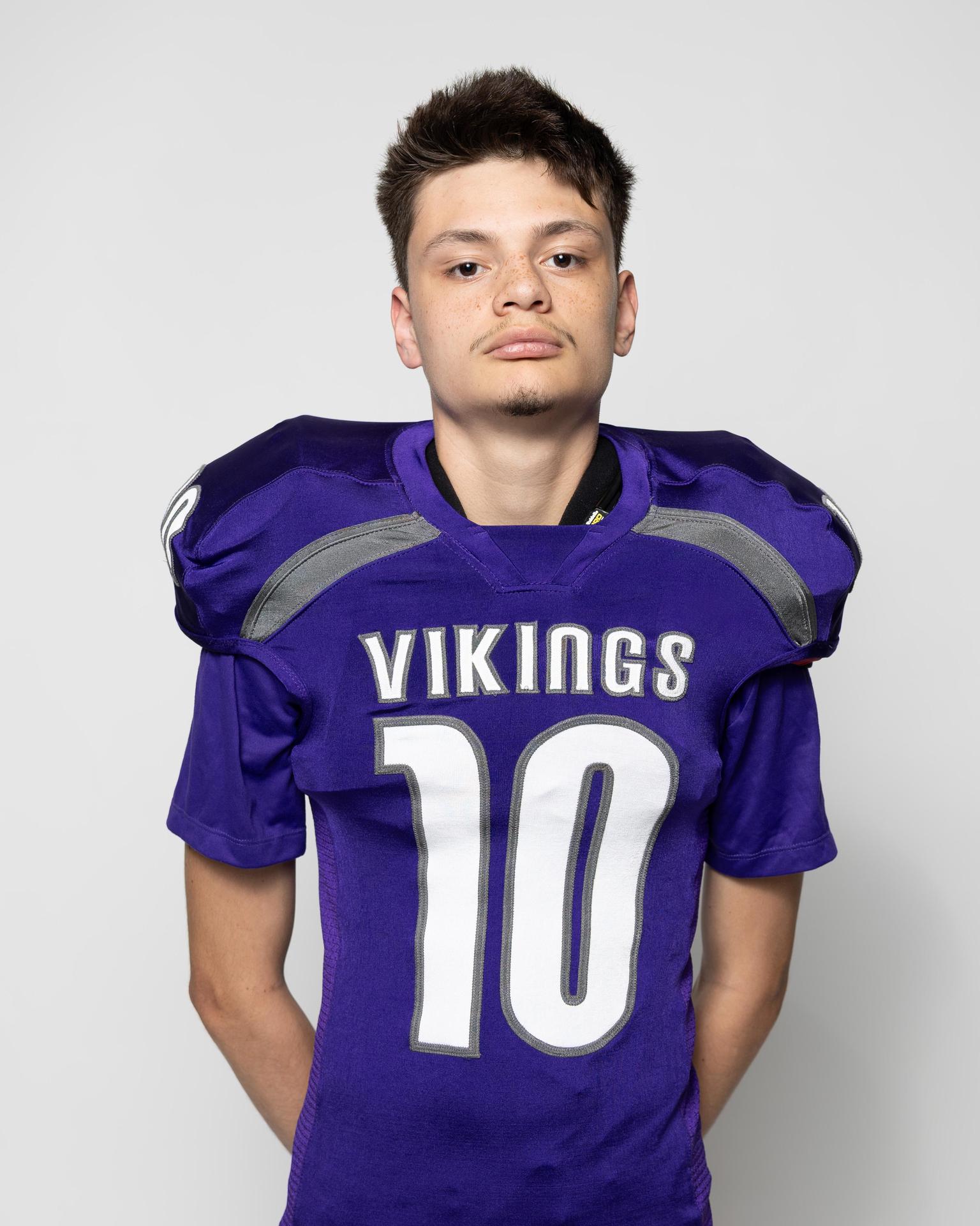 Young athlete in a purple football jersey with the number 10, standing confidently.