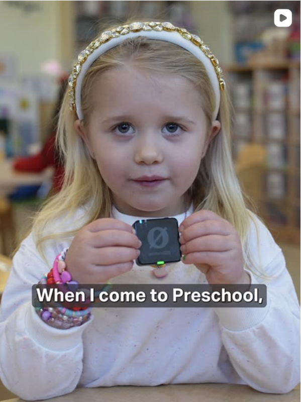 Child holding a microphone with closed captions reading 