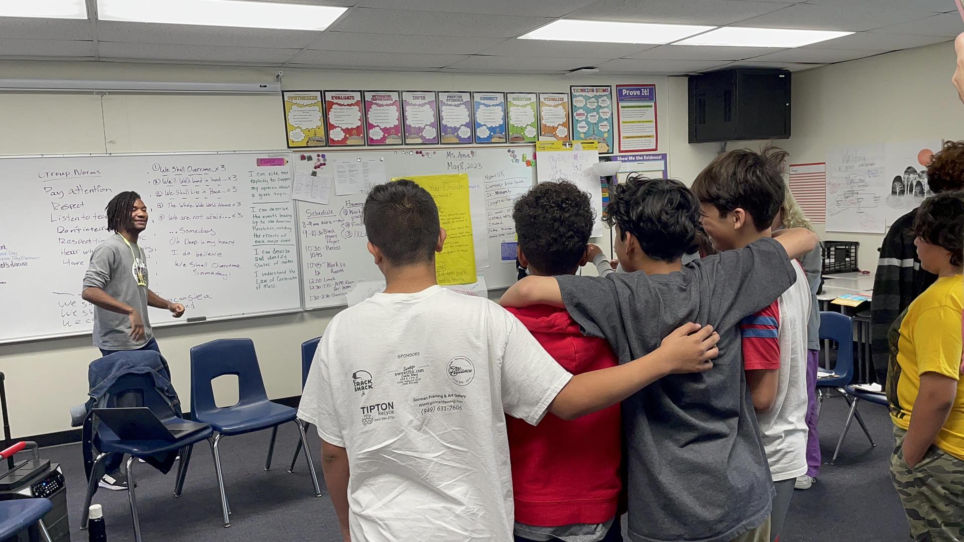 Students with arms on each other's shoulders showing inclusion