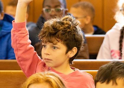 Child raising their hand during Meeting