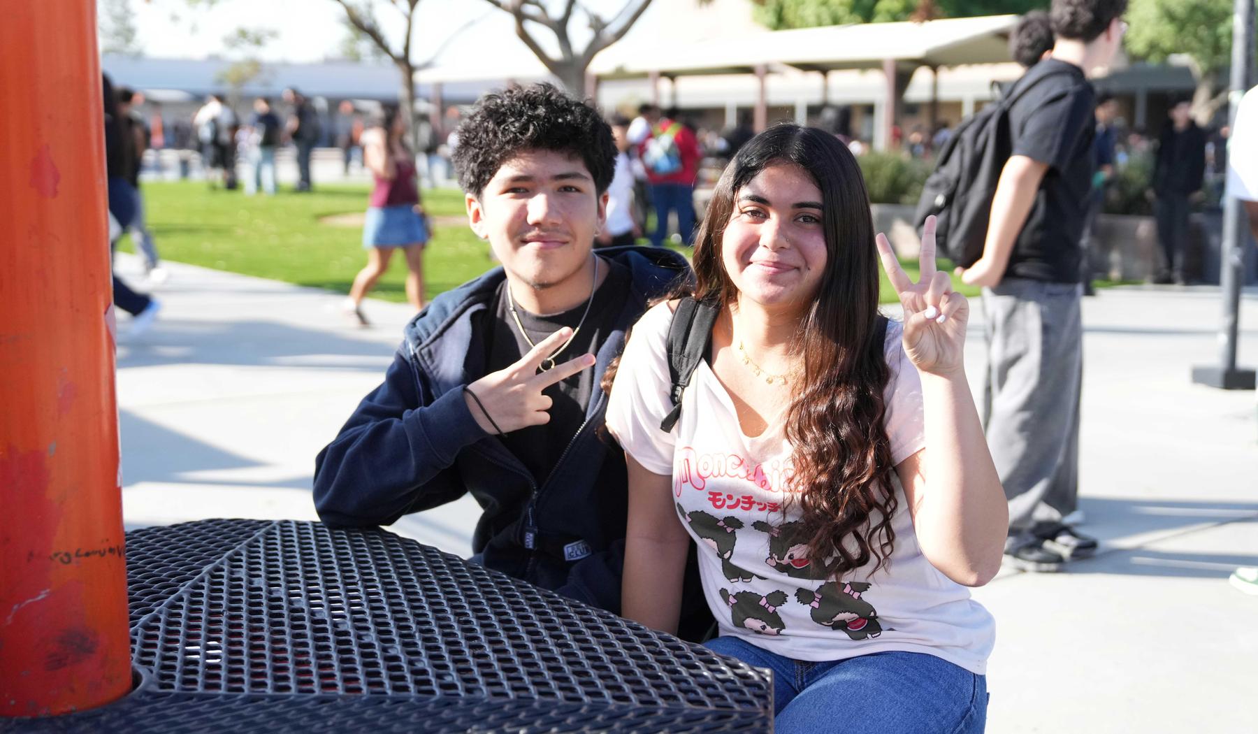two high school student giving "peace" signs
