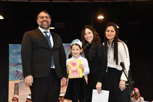 A first grader receives her siddur