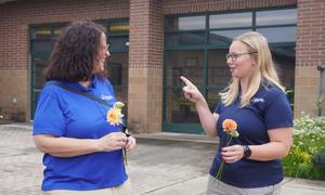 Two women talk before the ribbon cutting.