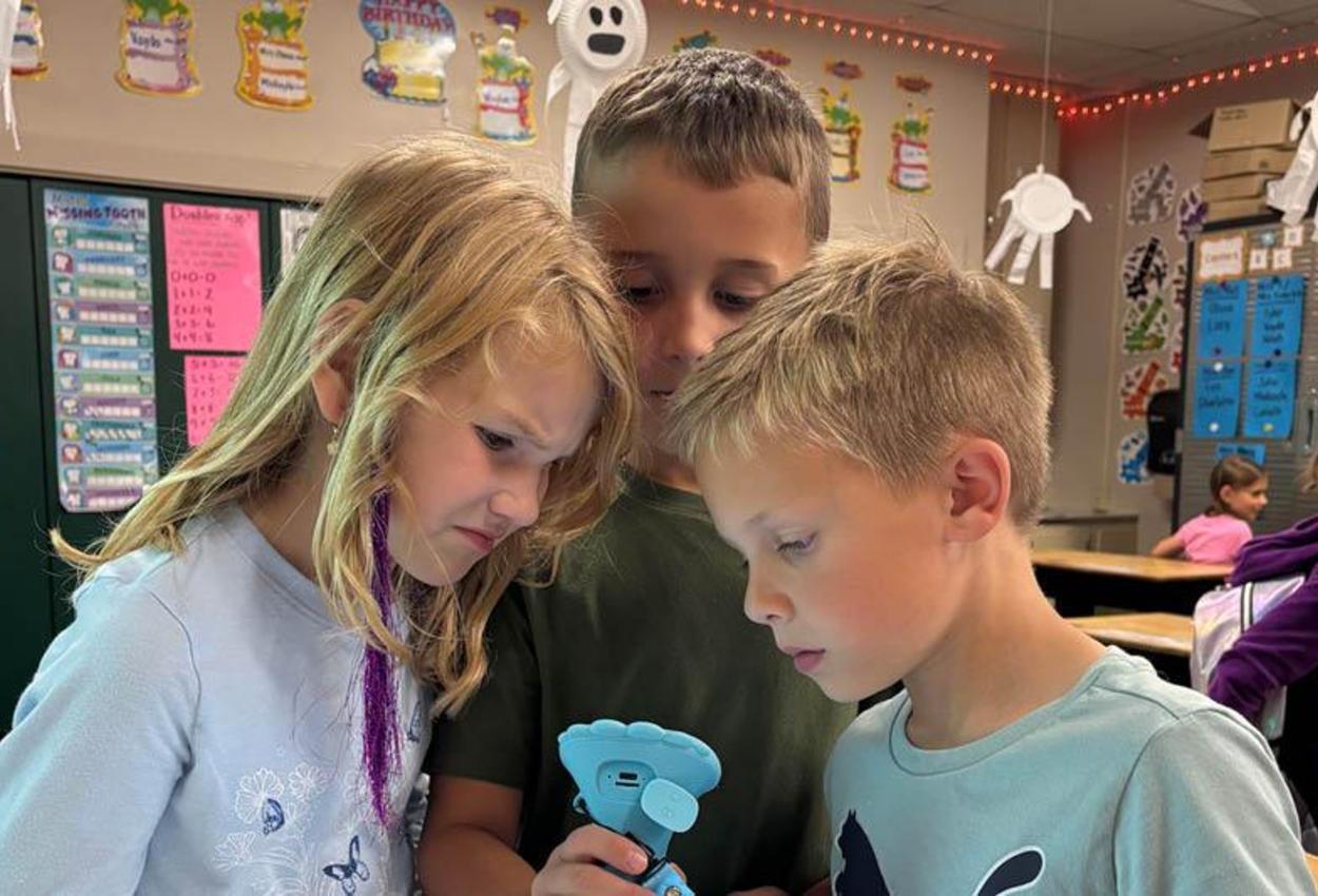 Zoe Miller, Waylon Jack, and Liam Driskill observe an image through the new microscope