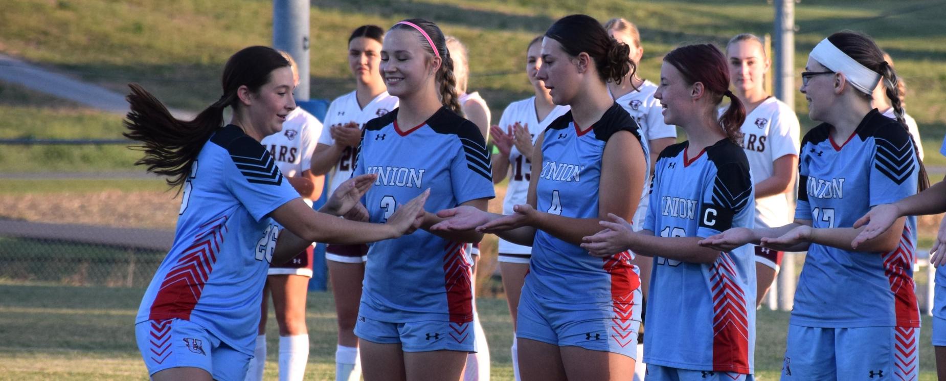 Soccer team high-fiving each other in a line