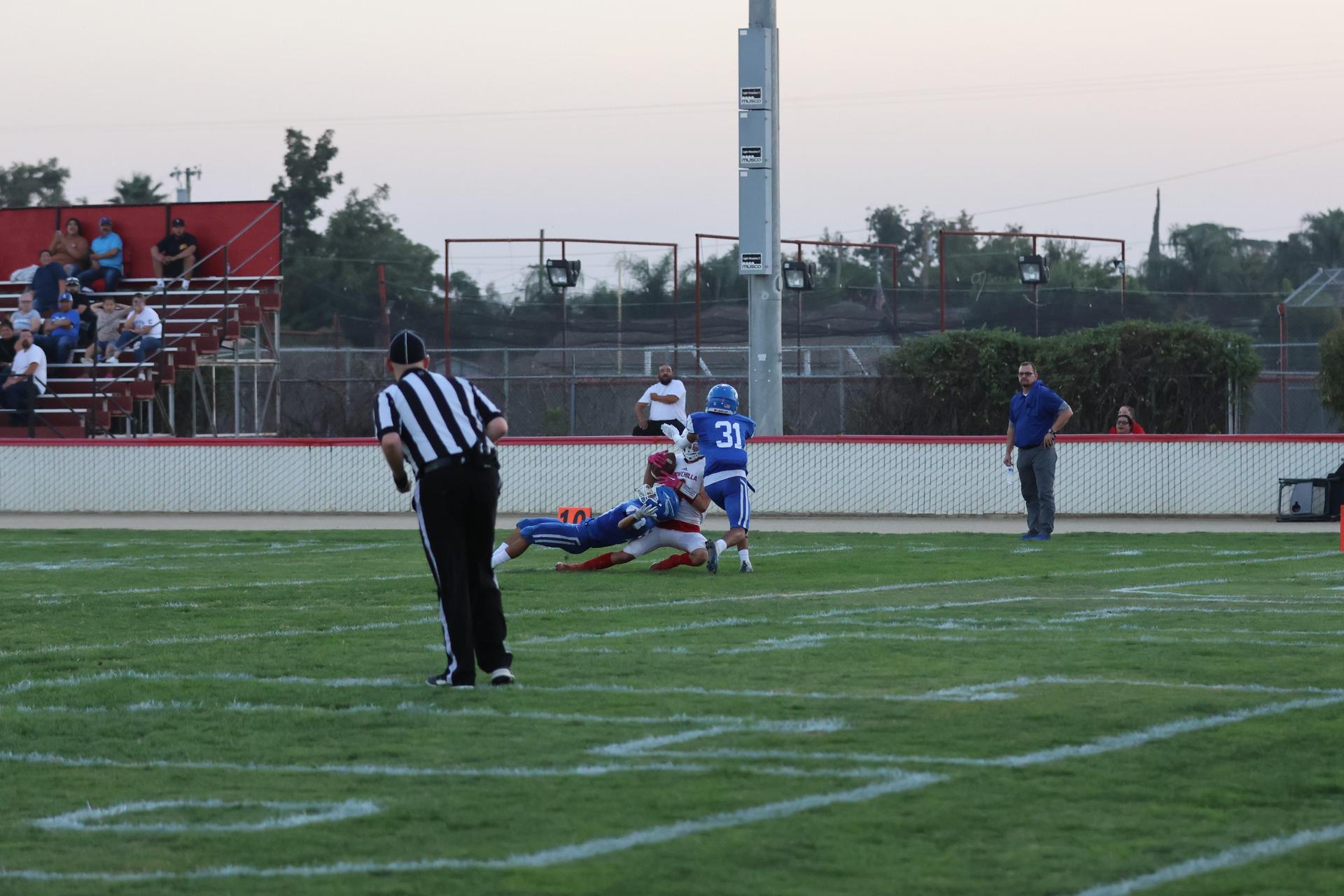 Junior Varsity football players in action against Caruthers