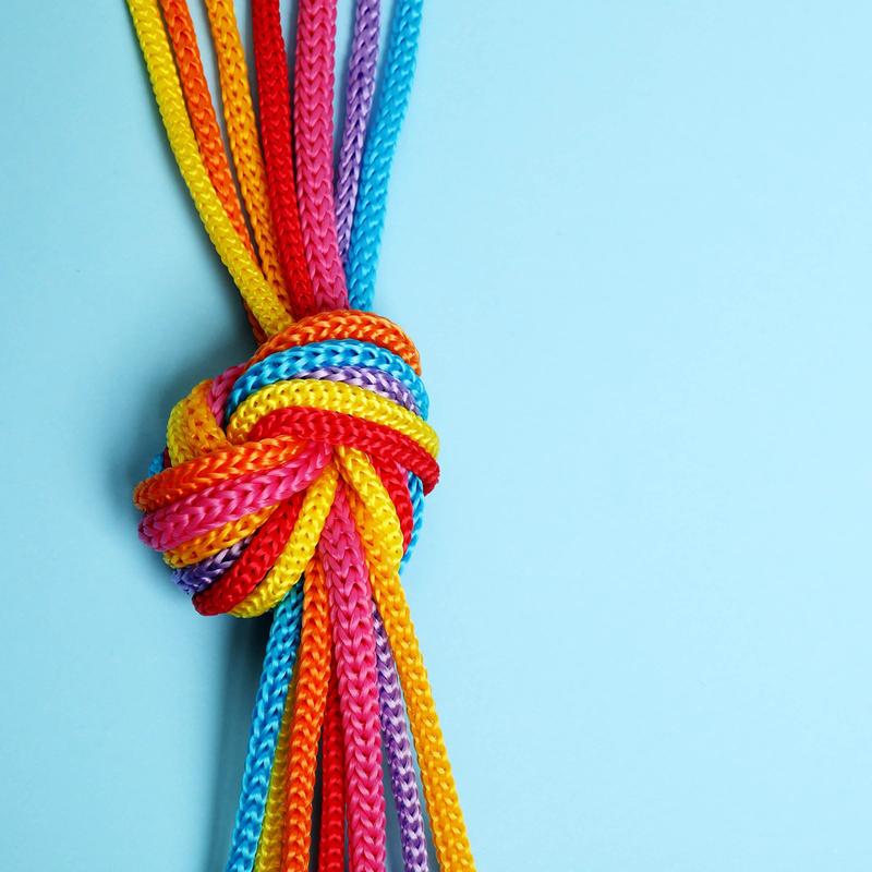 Colorful knotted ropes on a light blue background.