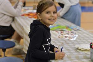 a girl doing a project at the fall festival