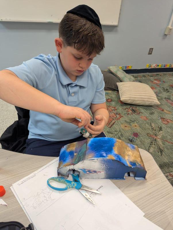 a fourth grade student working on one of his vintage cars
