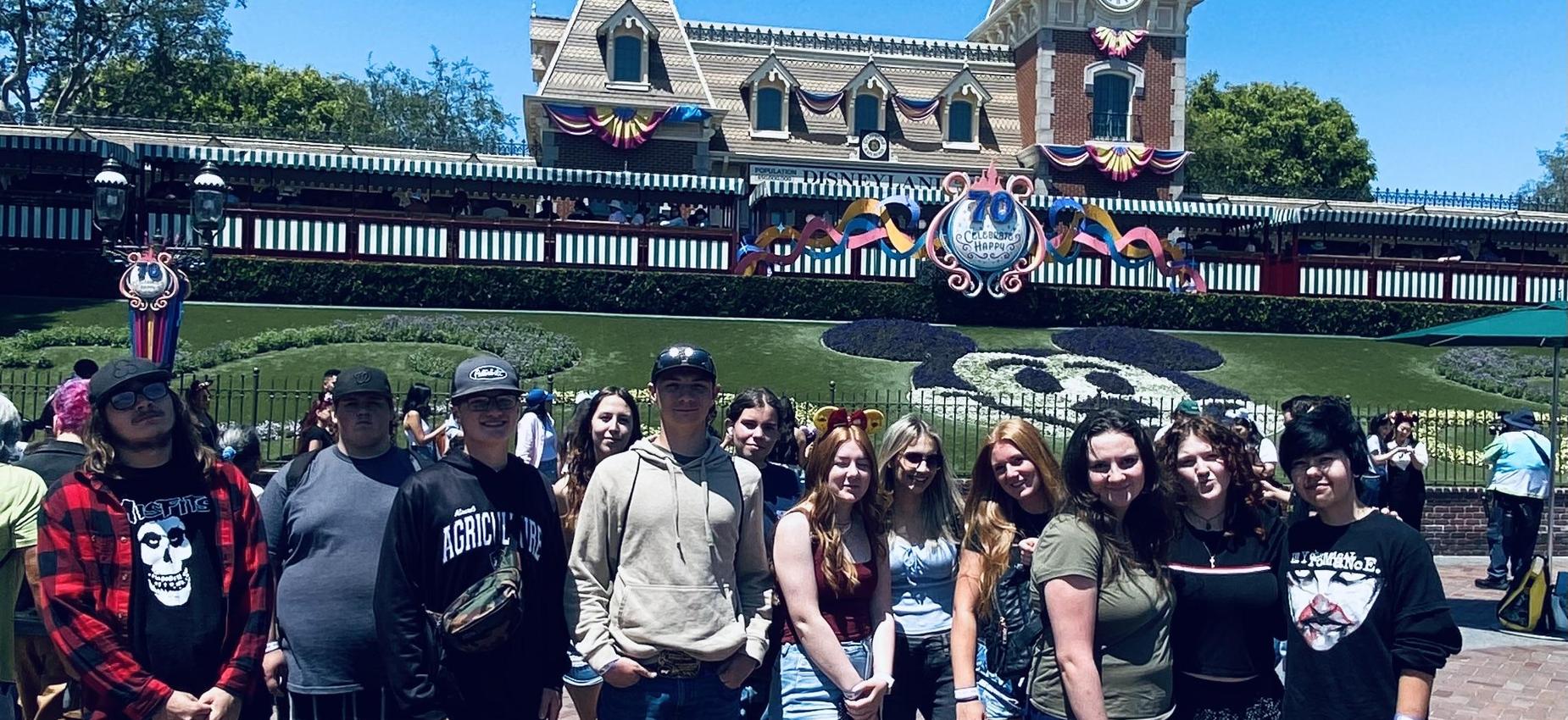 CAC students poses in front of a decorated Disneyland entrance.