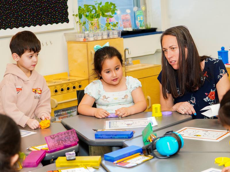 Young students working with their teacher in class