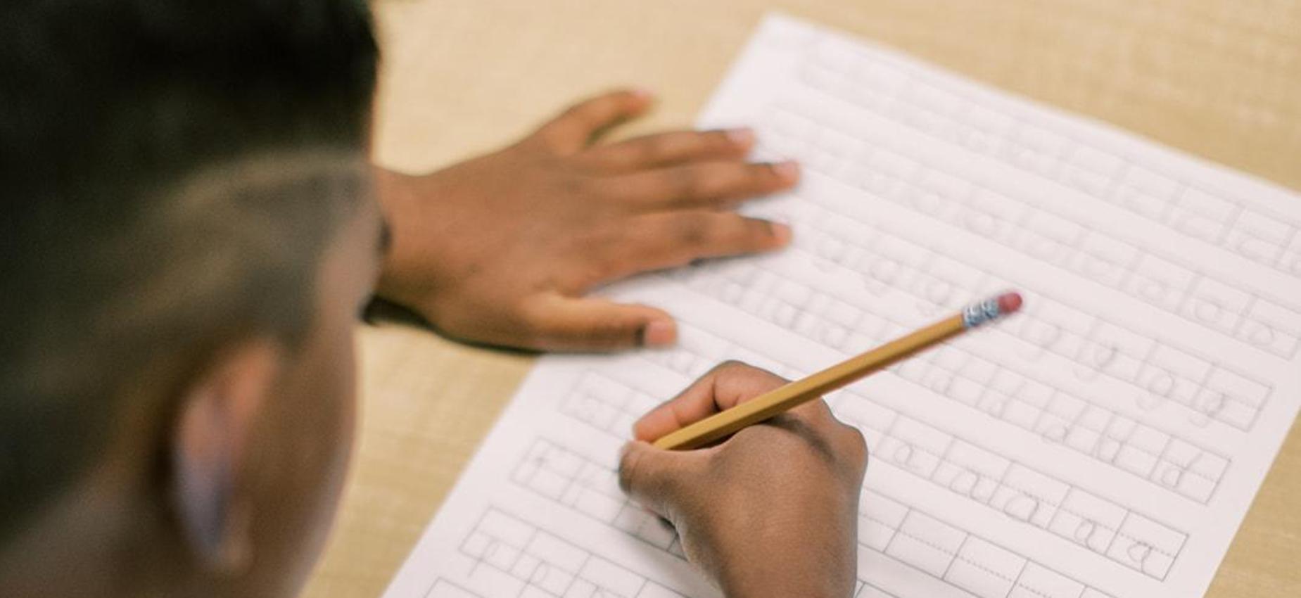 Student practicing handwriting on lined paper