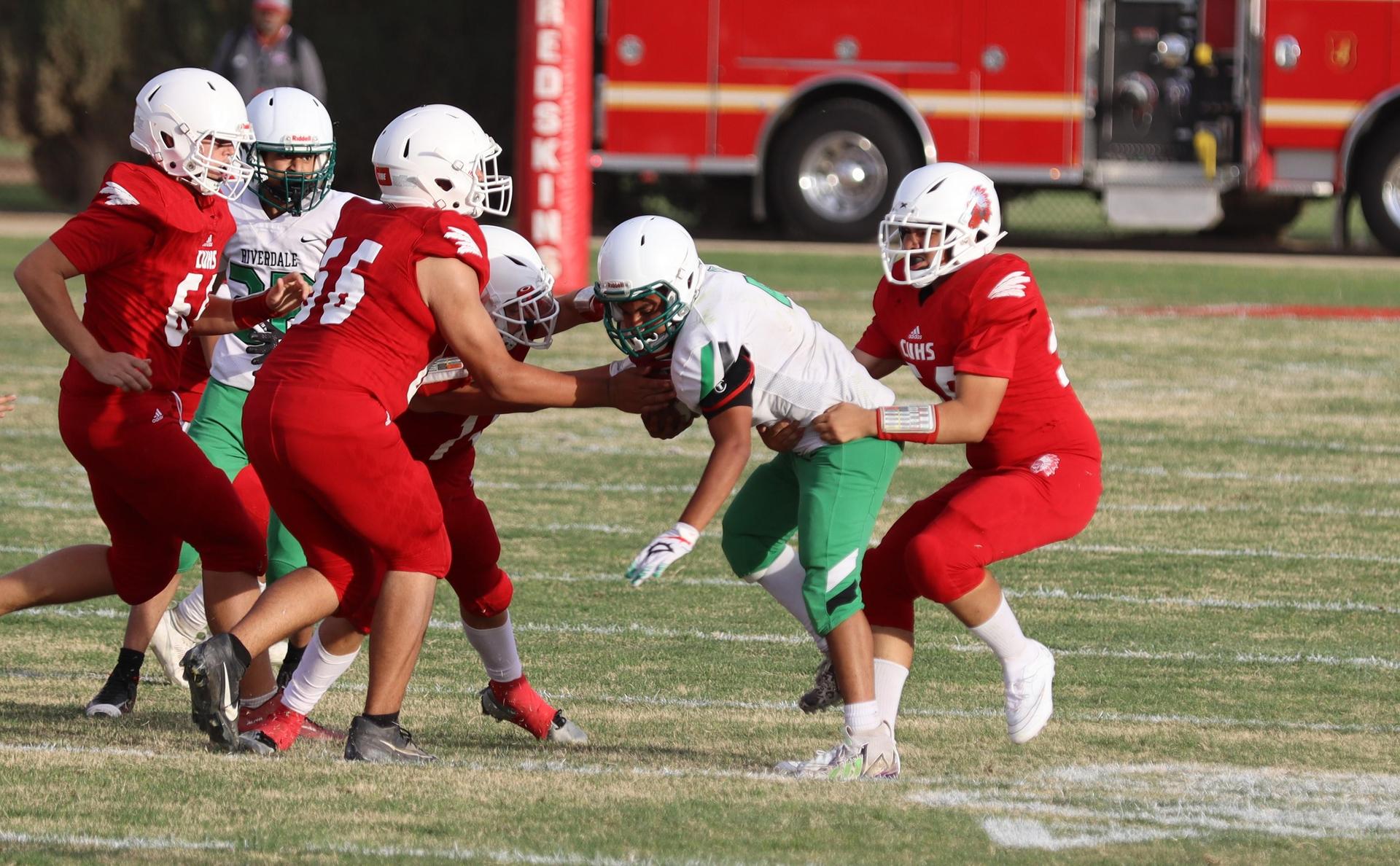  junior varsity football players in action against riverdale