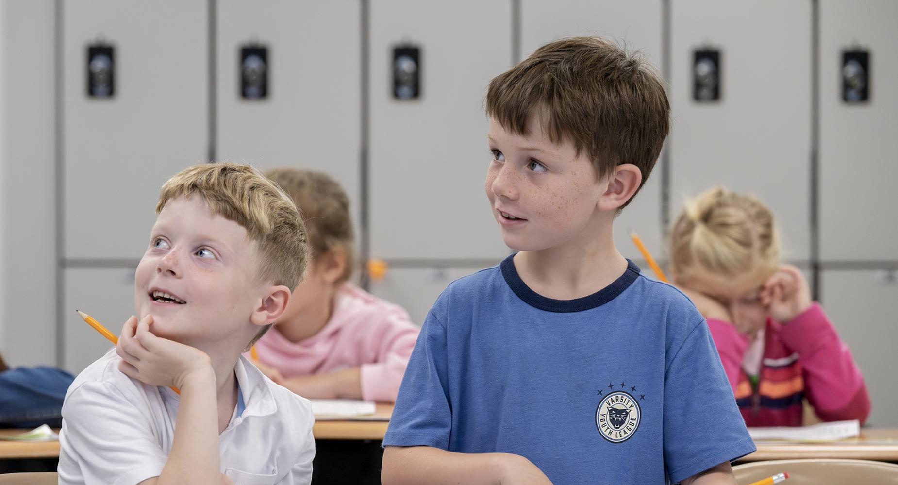 Two students smile while in class.