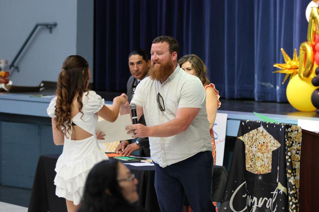 Principal Dewey hands diploma to Pomolita student