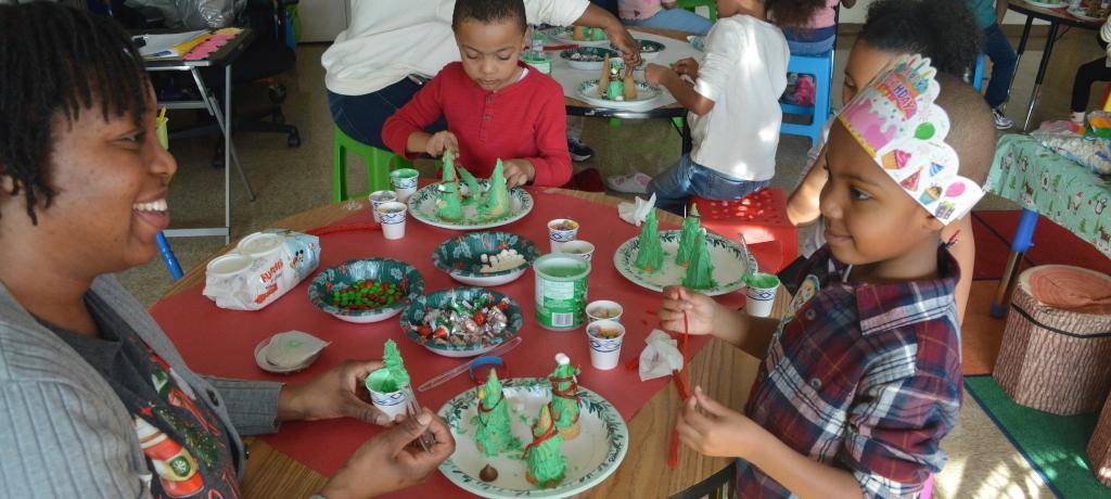 mom and her son apply frosting and candy to ice cream cones
