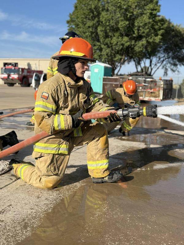 Fire academy student working the hose at a practice