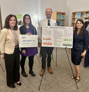 Smiling students stand with school projects