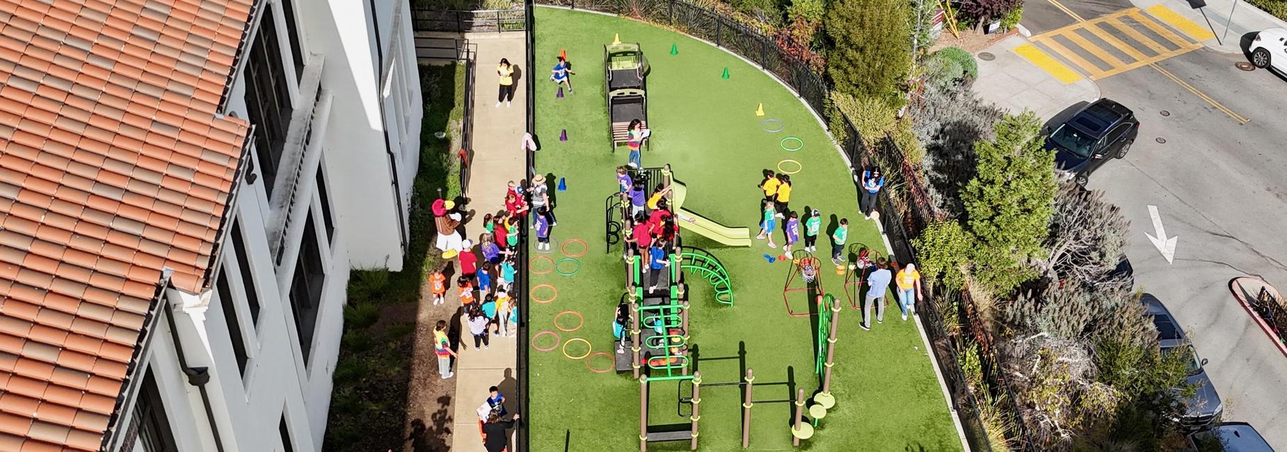 Aerial view of children playing on the Hoover Primary playground with colorful equipment.