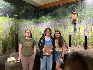 three girls standing inside of environmental center