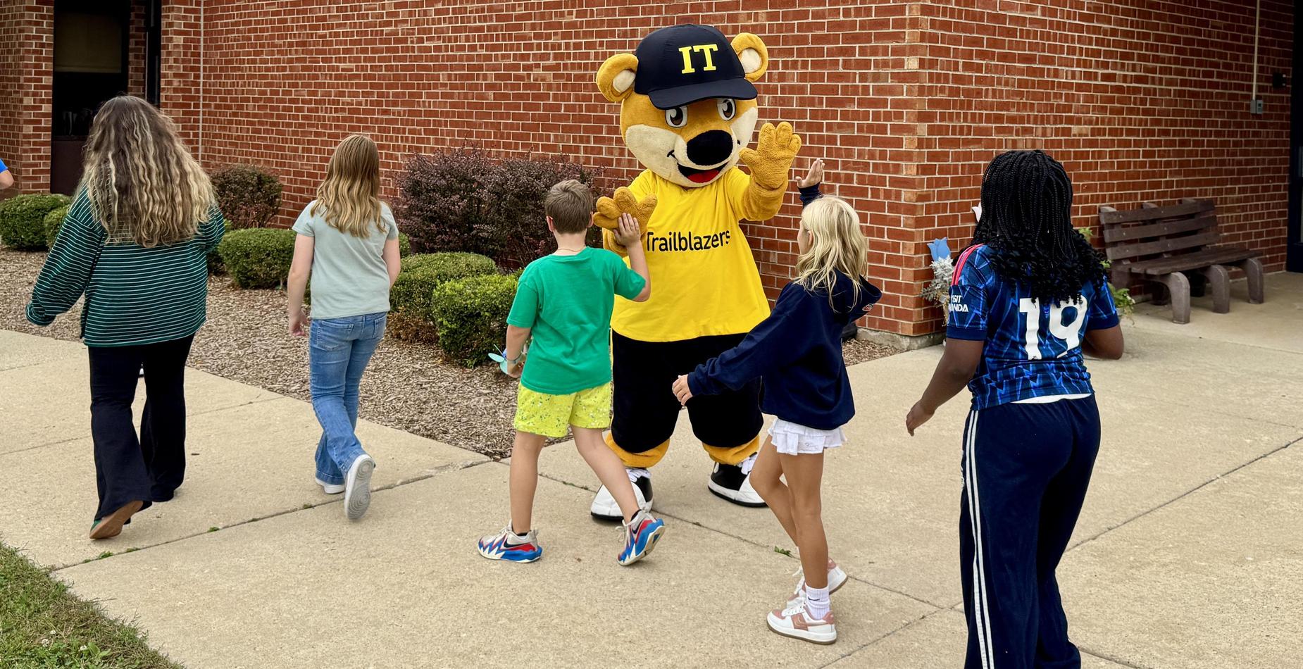 Students high five Scout during the school's Color Walk.