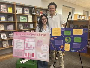 Smiling students stand with school projects