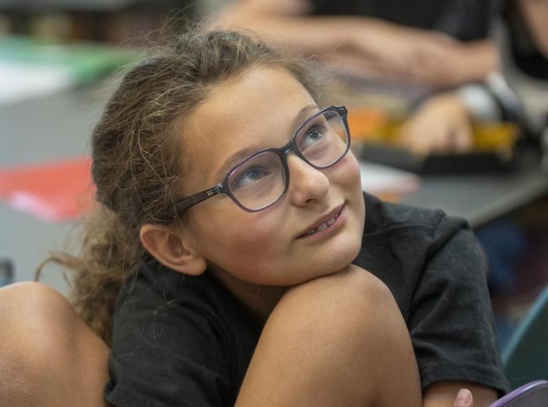Female student listening to teacher during class
