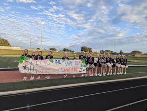 TKHS cheer team members wait for the team to race to the student section.