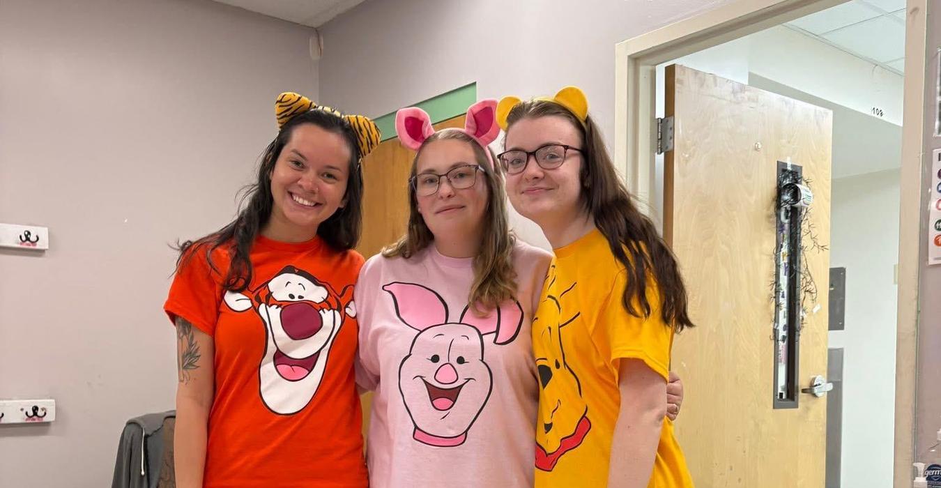 Three women in themed shirts of classic cartoon characters.