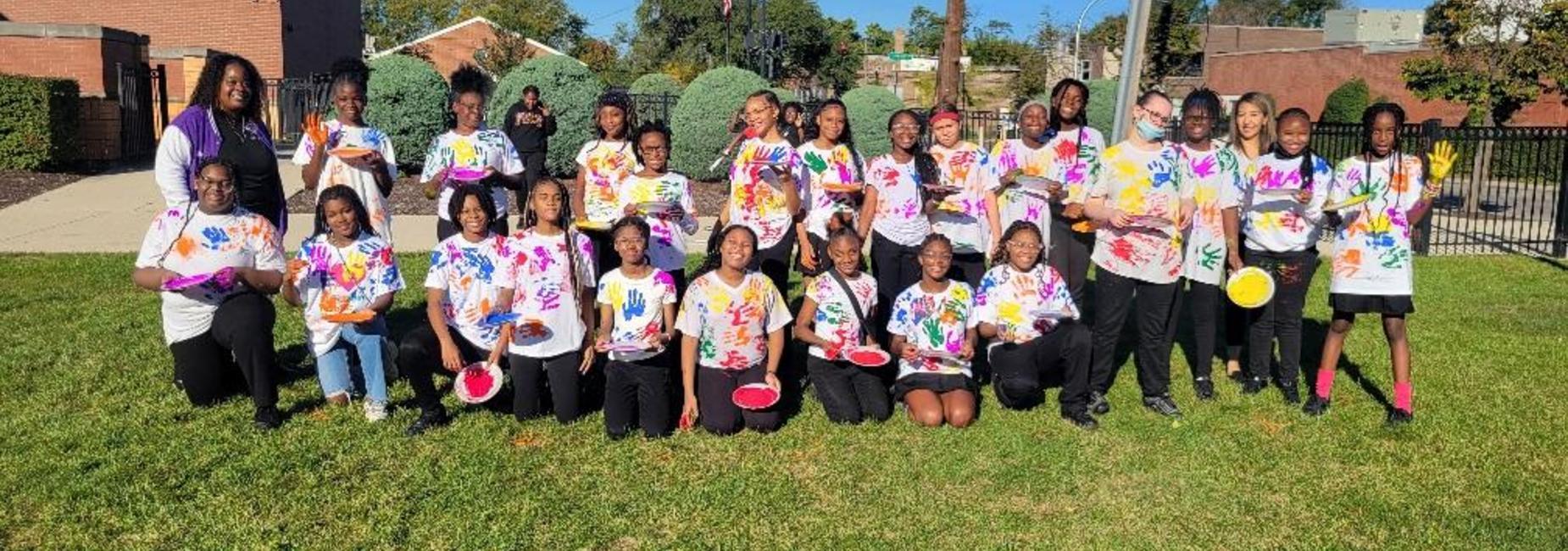 Students posing after handprint activity on PECS lawn