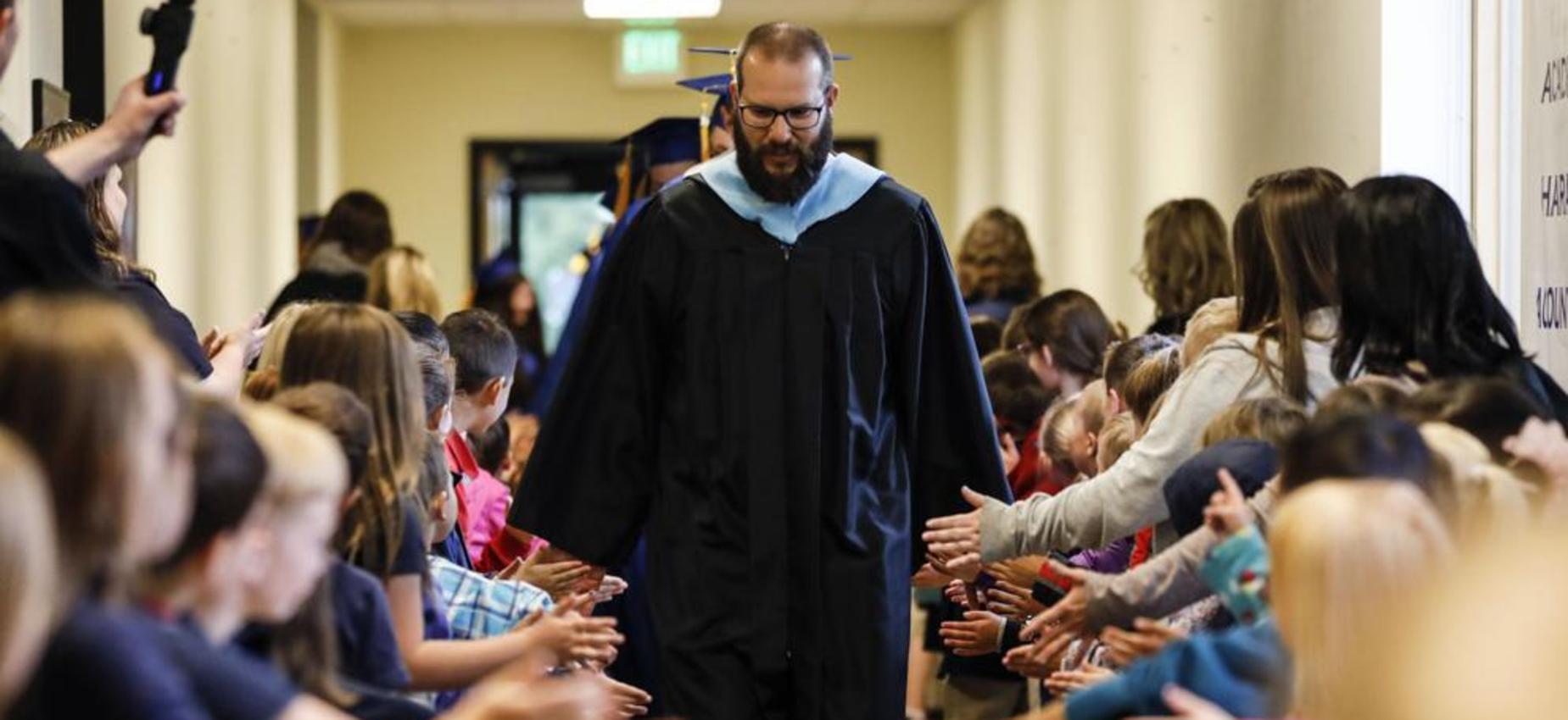Mr. Collins leading 2019 graduates down the hallway to the commencement ceremony
