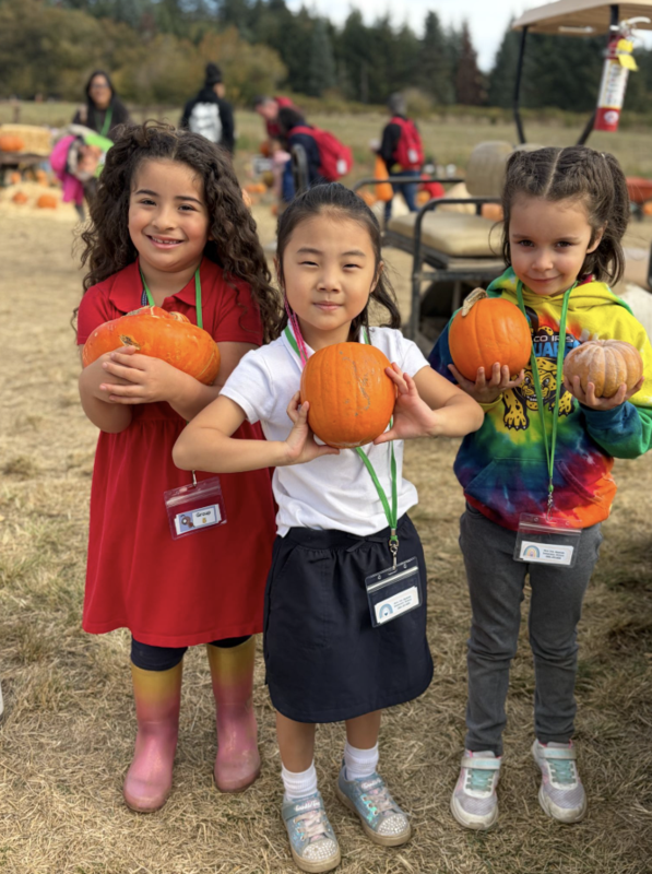 Arco Iris students hold pumpkins while on their field trip at the Plumpler Farm Pumpkin Patch.